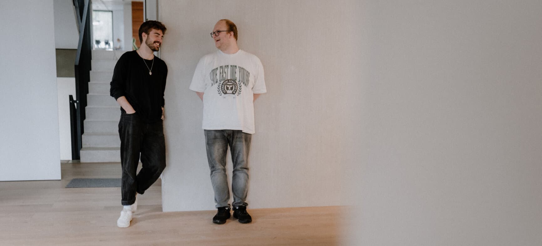 Zwei Männer stehen in der Agentur reaze und unterhalten sich.