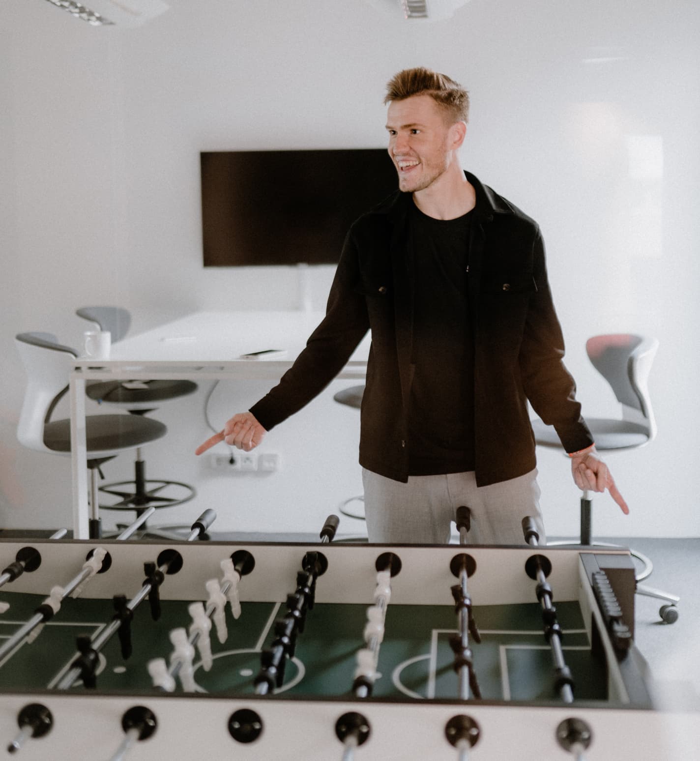 Ein Mann steht an einem Kicker und feiert seinen Sieg.