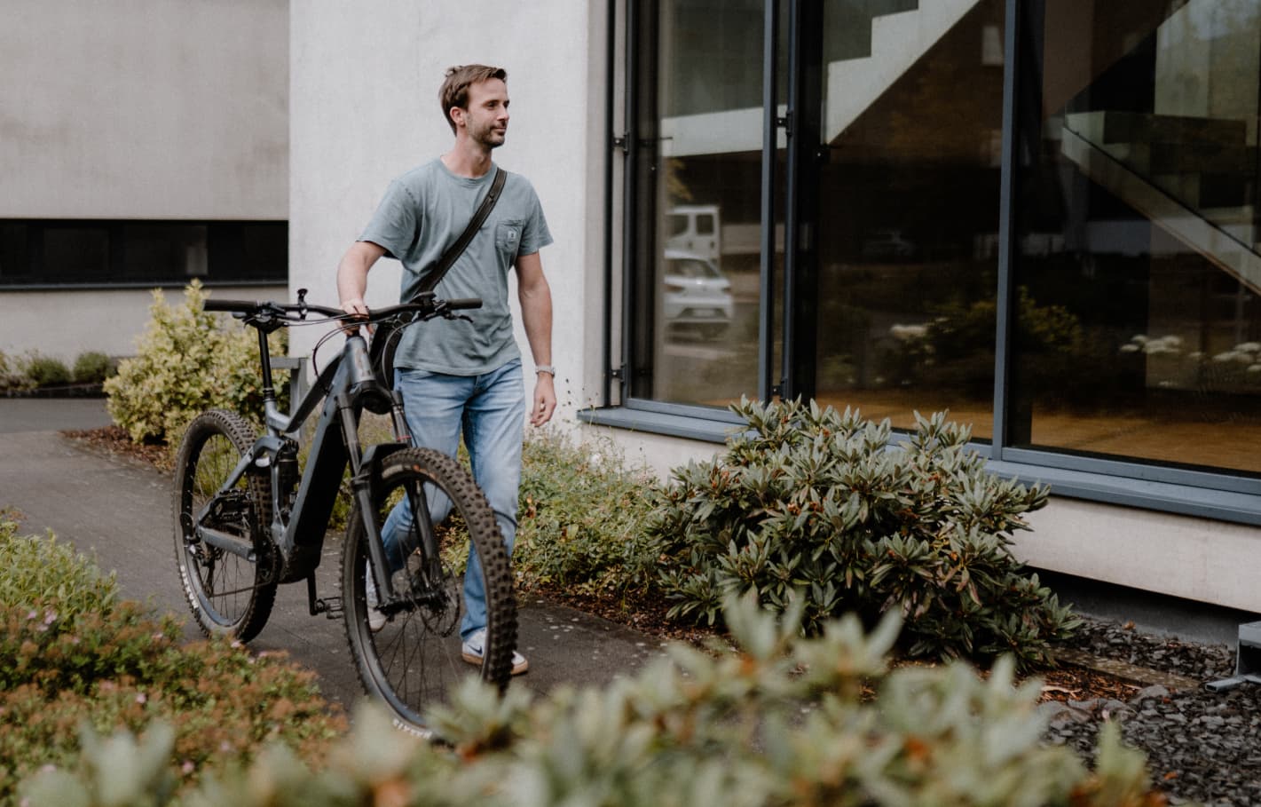Ein Mitarbeiter der Agentur reaze aus Siegen kommt mit seinem Fahrrad zur Arbeit.
